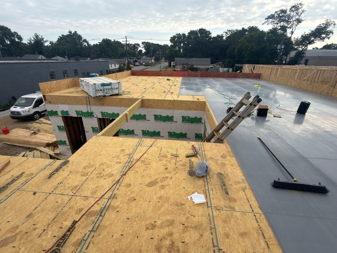 MAXTERRA package on exposed wood subfloor beside installed gray underlayment panels at The Railyard.